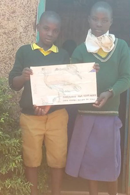 Schüler*innen der Chamchuzi-Grundschule mit ihren Kunstwerken über den Grauen Kronenkranich Foto: Nature Tanzania