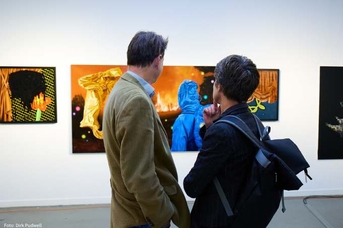 Zwei Personen betrachten Kunstwerke