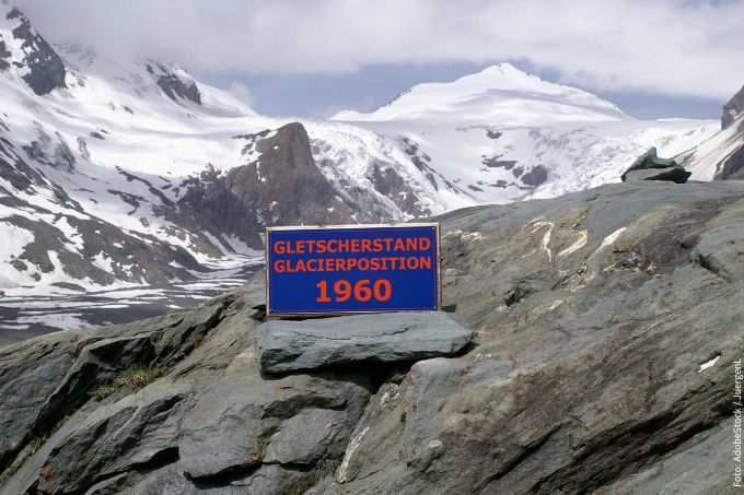 Schild mit Information über den Gletscherstand 1960 in den Bergen
